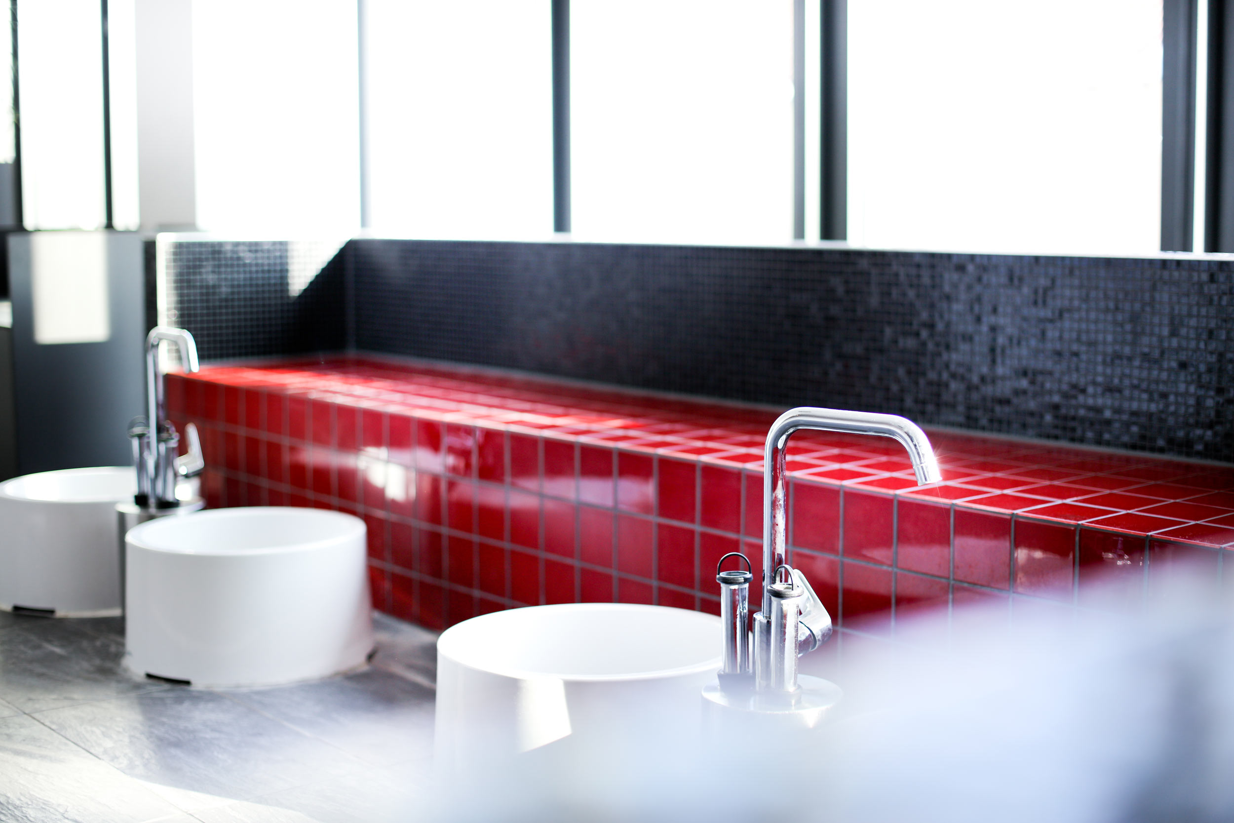 Zu sehen ist eine stilistische Interpretation eines Fusbadebereiches im Wellnessbereich eines Sportstuios. Der Wellnessbereich in dieser Ecke ist in den Farben, weiss, Anthrazit und rot.